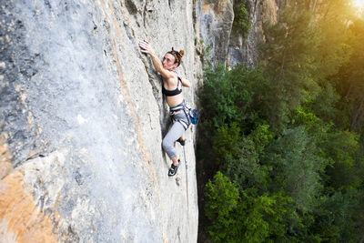 High angle view of woman climbing rock