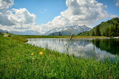 Scenic view of lake by mountains against sky