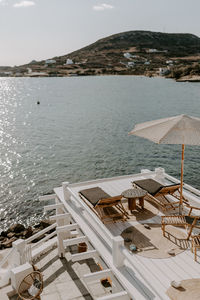 High angle view of recliners on deck by sea