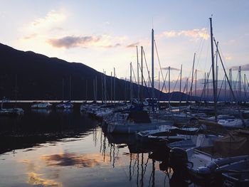 Sailboats in sea at sunset