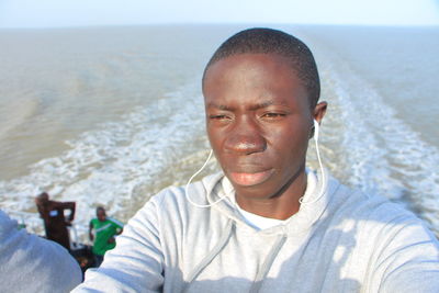 Close-up of man wearing headphones on boat