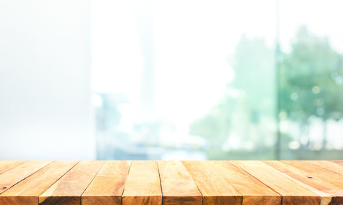 Close-up of wooden table against wall