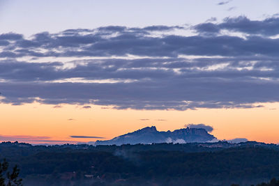 Scenic view of snowcapped mountains against sky at sunset