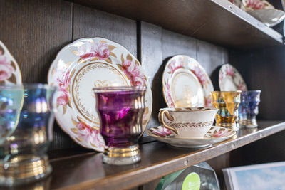 Variety of white plates tea cups and designer glass for sale at store