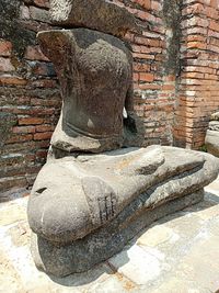 Old statue against brick wall