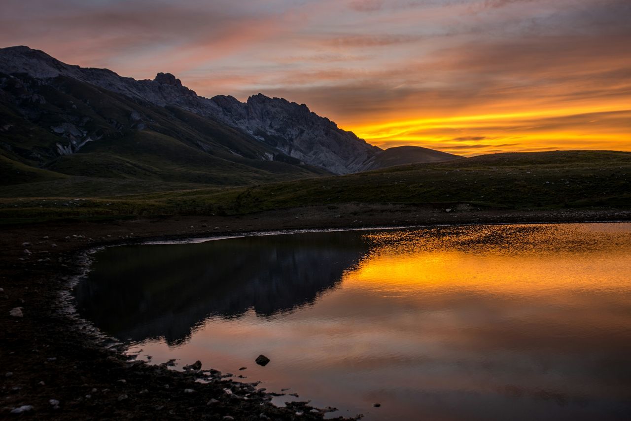 sunset, scenics, tranquil scene, water, beauty in nature, tranquility, reflection, sky, orange color, idyllic, lake, mountain, nature, cloud - sky, majestic, cloud, non-urban scene, dramatic sky, waterfront, outdoors