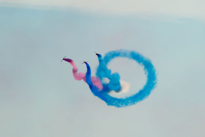 Low angle view of airplane flying against blue sky