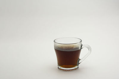 Close-up of drink served on table against white background