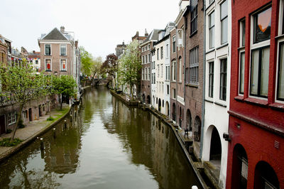 Canal amidst houses against clear sky
