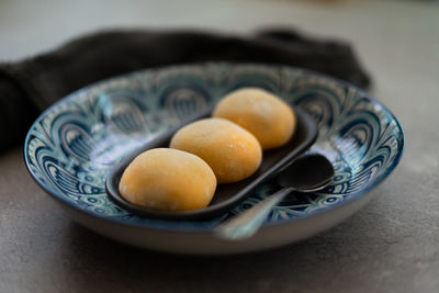 Yellow-colored japanese mochi in rice dough and on a pattern blue plate background.