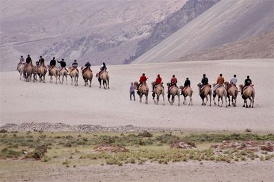 Group of people on desert against sky