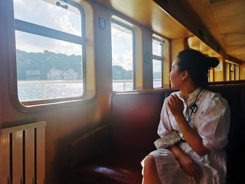 Woman looking through steamboat  window