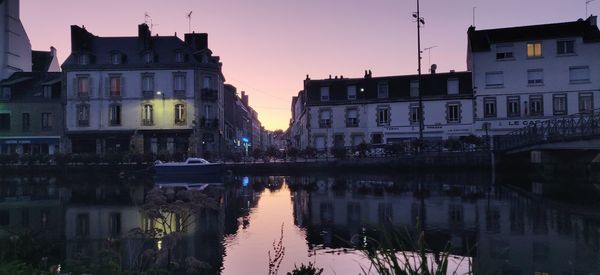 Reflection of buildings in river at sunset