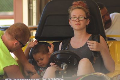 Portrait of mother sitting with son in bumper car at amusement park