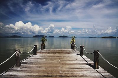 Wooden pier over sea against sky