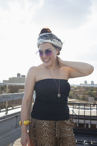 Portrait of a young woman wearing sunglasses and a bandana