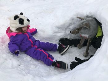 People wearing warm clothing while playing on snowy field