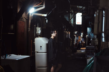 MAN STANDING IN ILLUMINATED ROOM