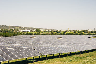 Solar panels in rows against sky at power station