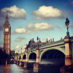 Bridge over river against cloudy sky