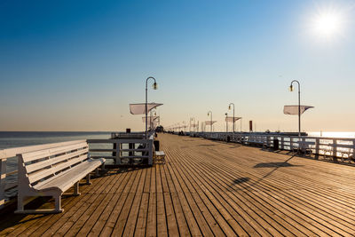 Pier on sea against clear sky during sunset