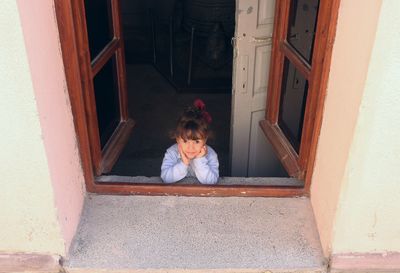 High angle portrait of girl seen through window