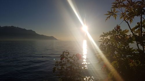 Scenic view of sea against bright sun