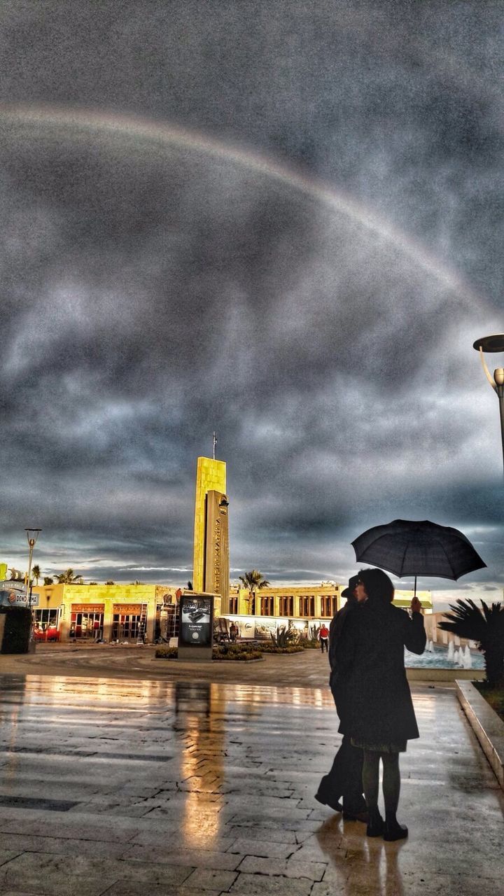 FULL LENGTH OF WET RAINBOW IN CITY