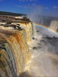 Scenic view of waterfall against sky