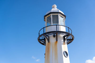 Low angle view of lighthouse against clear blue sky