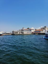 View of buildings by sea against clear sky