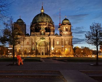 View of illuminated building in city against sky