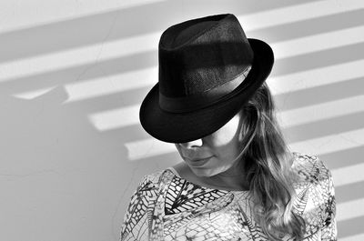 Woman wearing hat against wall