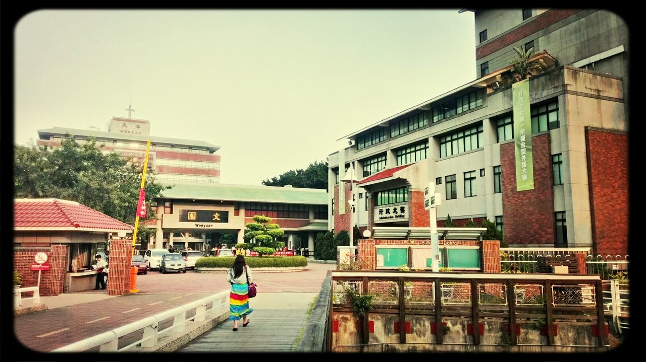 building exterior, architecture, transfer print, built structure, auto post production filter, lifestyles, city, men, walking, full length, person, street, leisure activity, city life, rear view, clear sky, residential building, residential structure