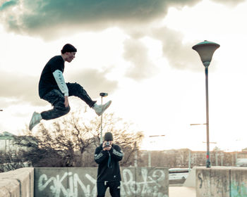 Man playing in street against sky