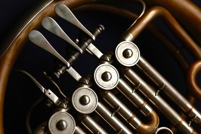 Cropped image of french horn against black background
