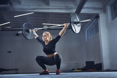 Woman doing overhead squat exercise at gym