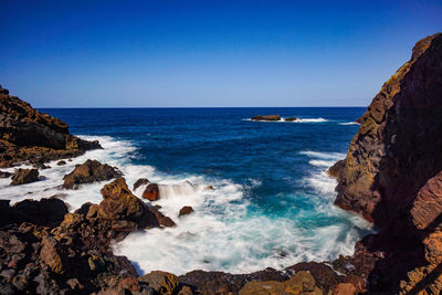 Scenic view of sea against clear blue sky