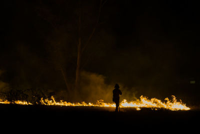 Silhouette of man with fire crackers at night