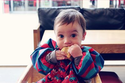 Portrait of cute boy eating at home