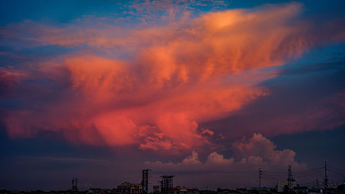 Low angle view of silhouette buildings against dramatic sky