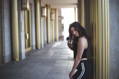 Side view of young woman standing in corridor