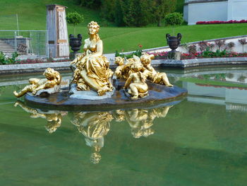Statue by lake against fountain