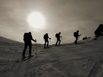 Silhouette people walking on snow covered land. on a skitour in the tyrol, austria.