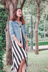 Young woman standing on tree trunk