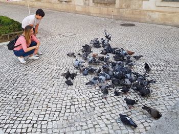 High angle view of people sitting on footpath