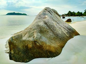 Scenic view of rocks on beach against sky