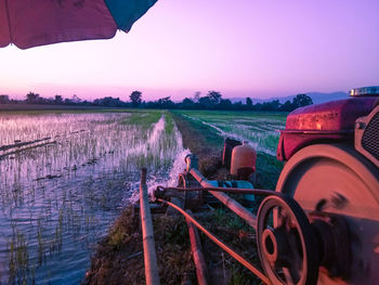 Agricultural field against sky at sunset