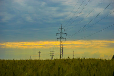 Electricity pylon on field against sky