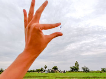 Cropped image of person on field against sky